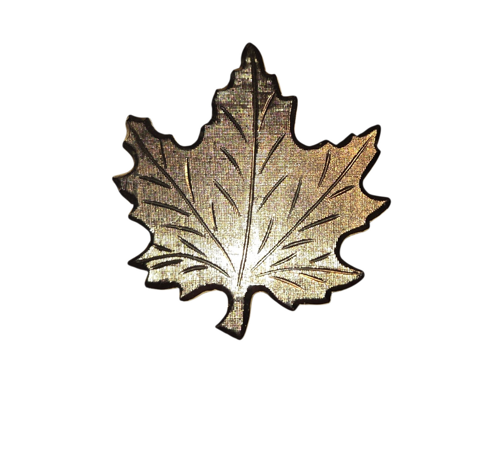 Front of vintage gold-tone maple leaf brooch with textured surface and raised veins
