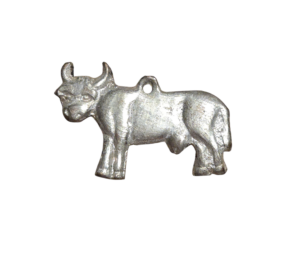 Front of vintage silver-tone bull pendant with horns and raised body details