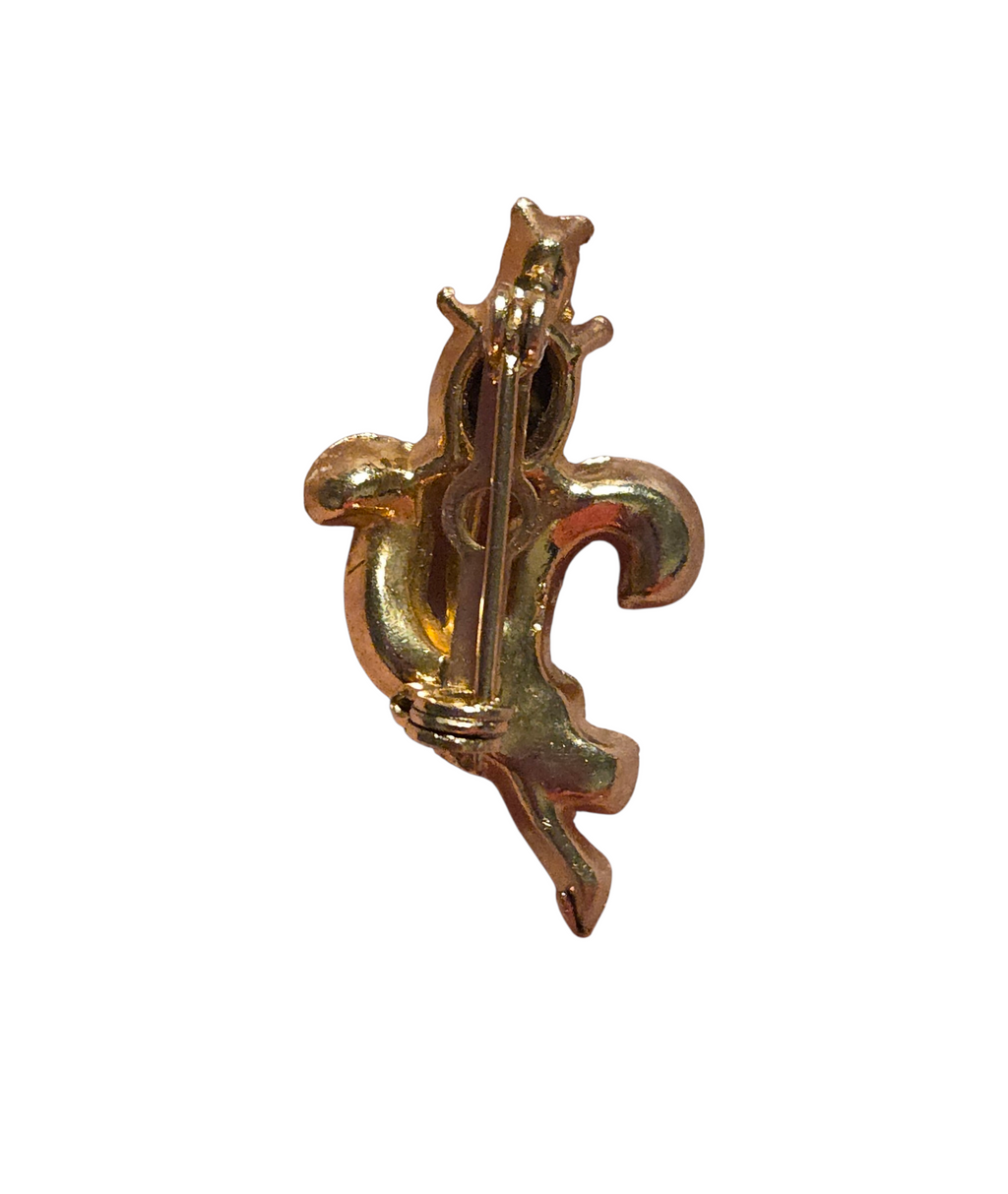 Reverse of gold-tone rhinestone pin showing clasp and surface wear