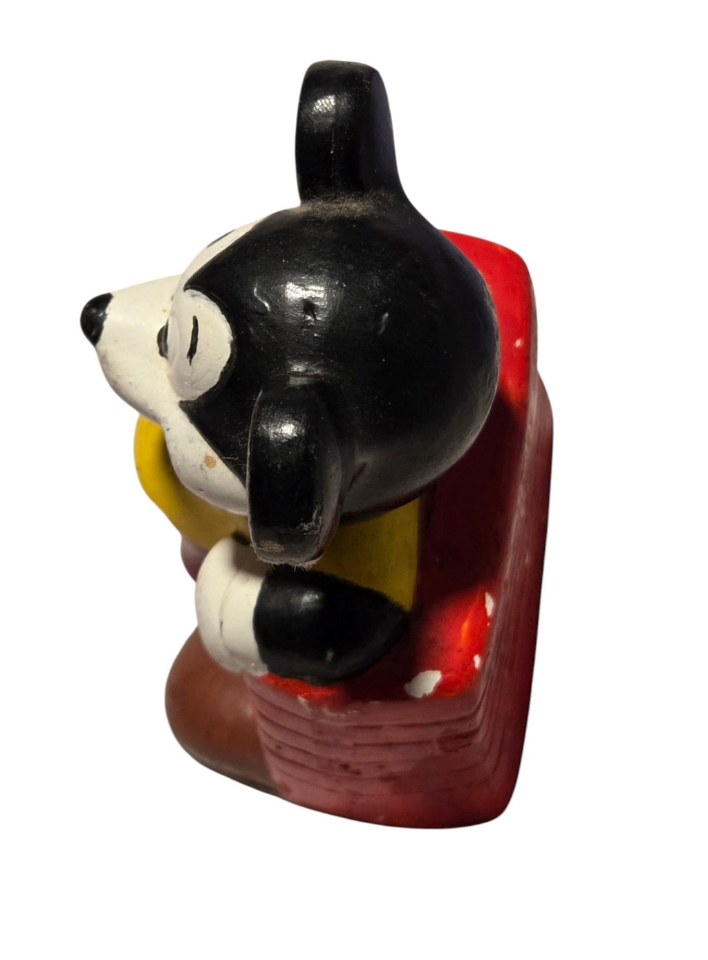 Mickey Mouse figurine side and red brick wall