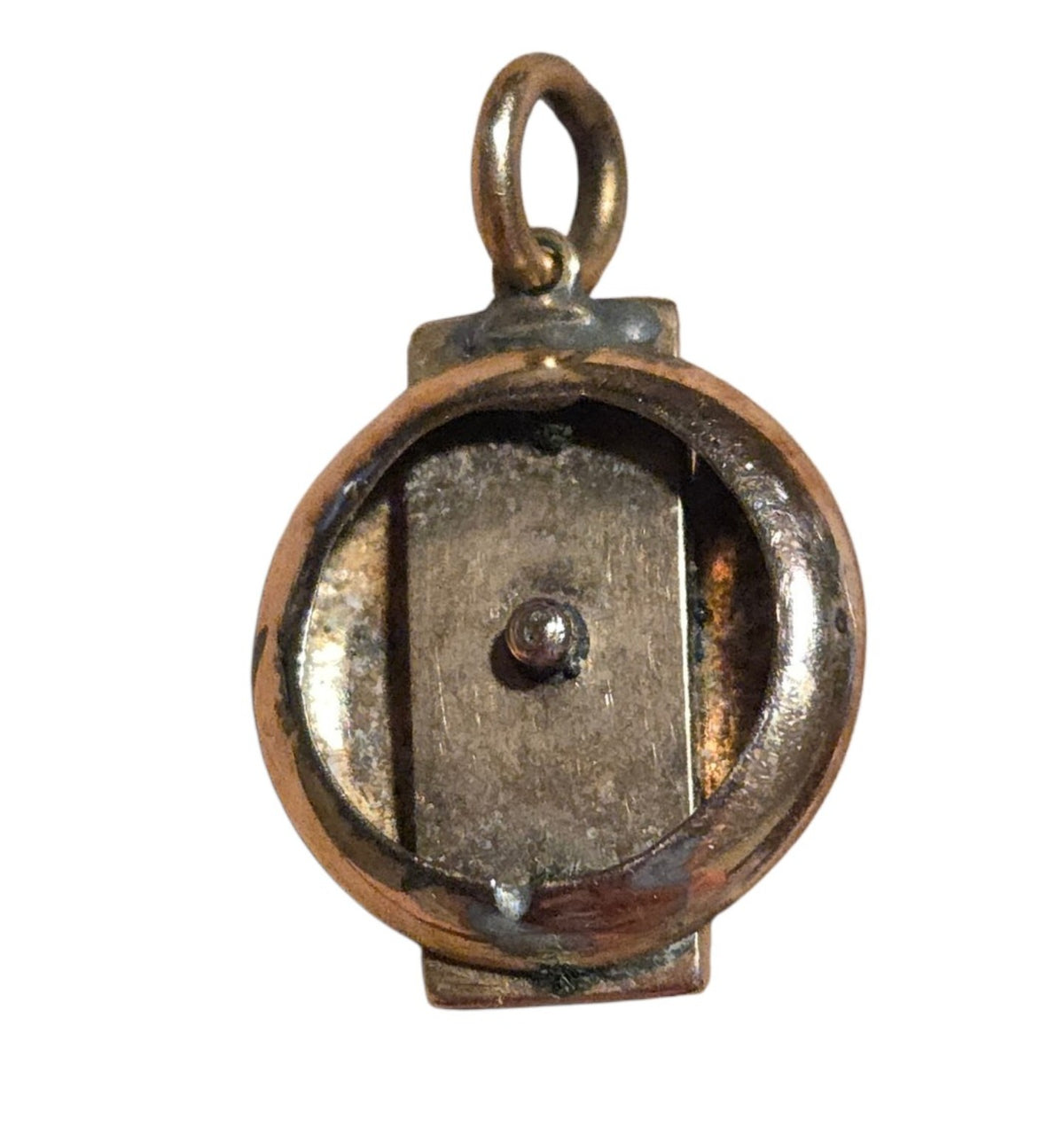Back of vintage pendant showing surface wear and discoloration