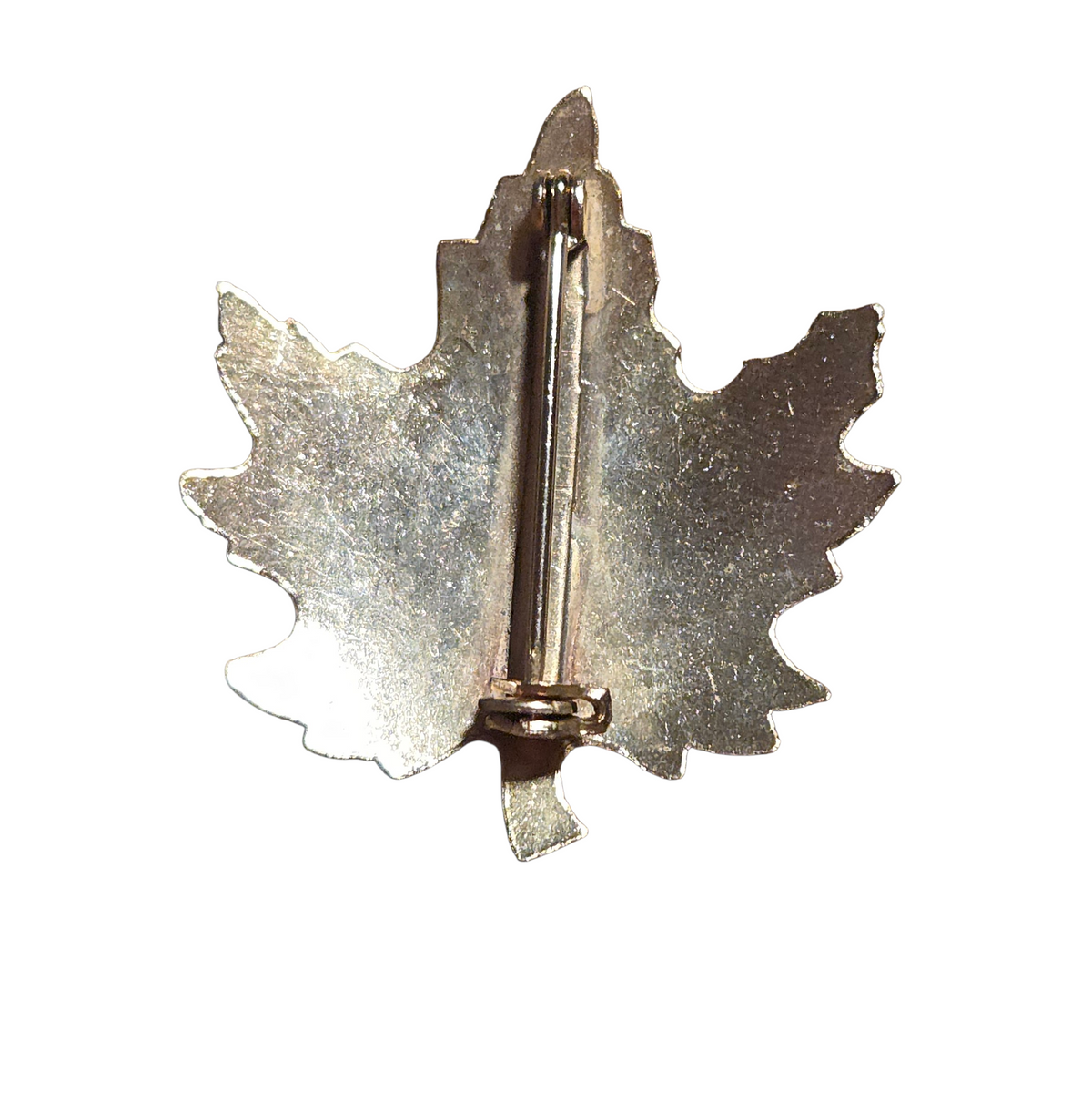 Back of vintage maple leaf brooch showing pin and clasp with surface wear