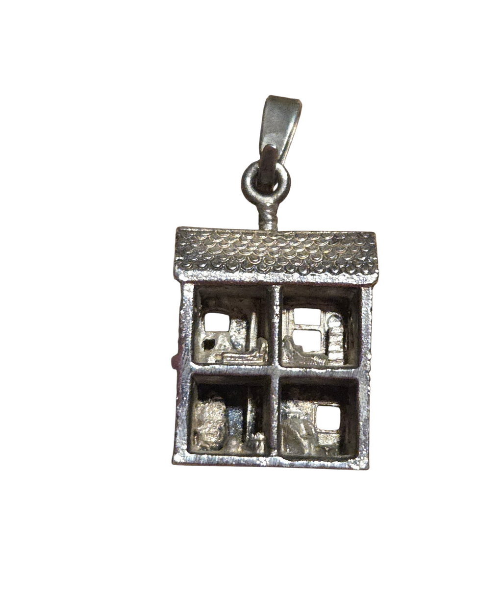Reverse of dollhouse charm showing four miniature furnished rooms