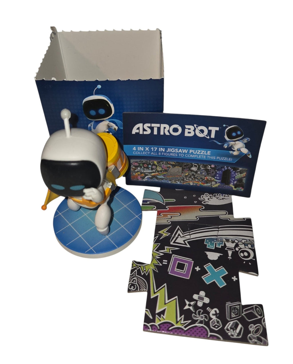 Stranded Bot mystery figure with opened blind box, insert and pictured puzzle pieces