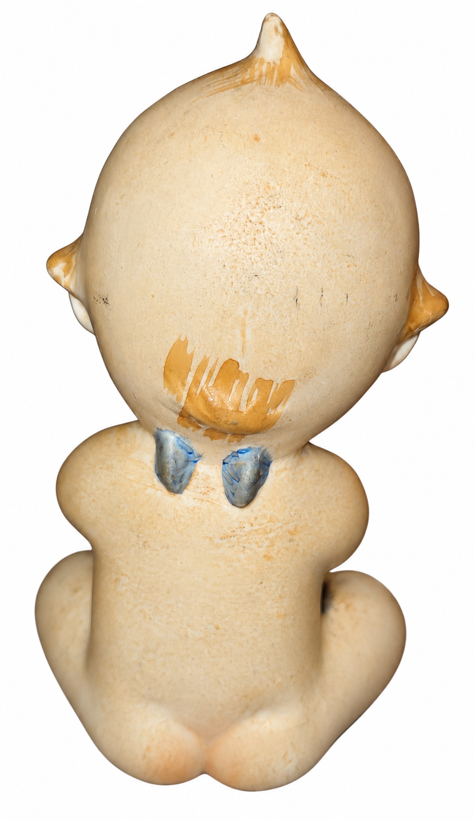 Vintage seated Kewpie ceramic figurine rear blue wings view with original wear on white background