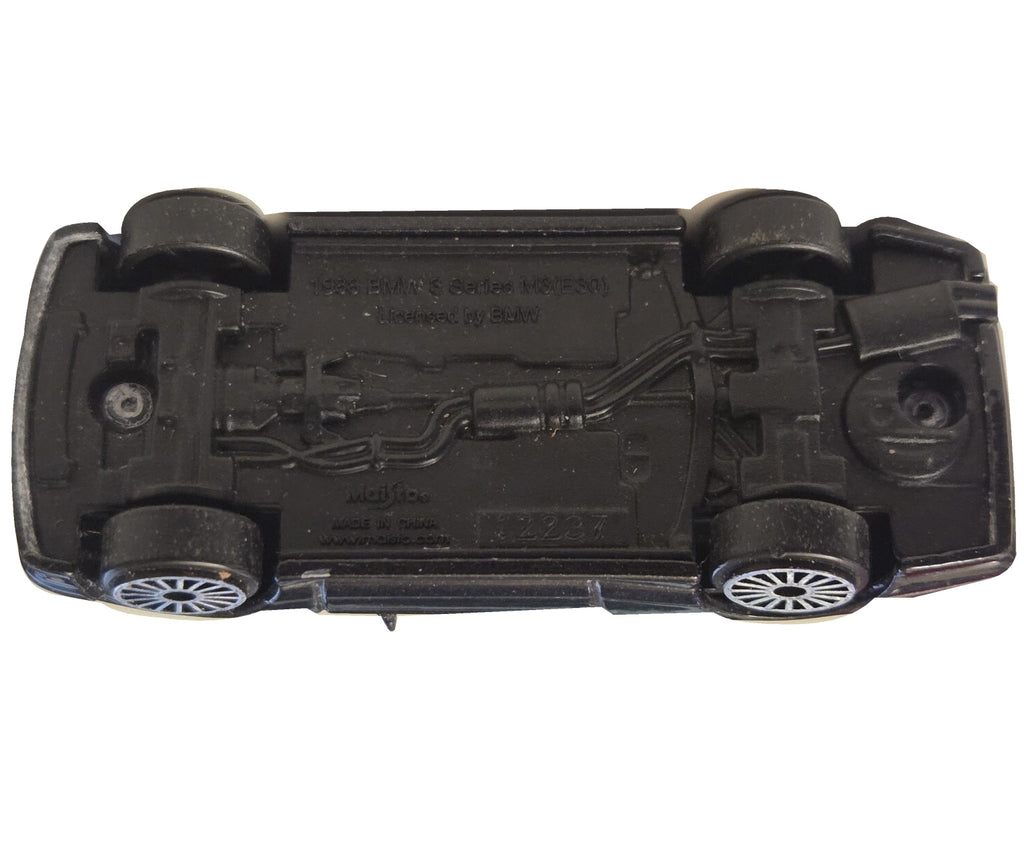 Pre-owned Maisto 1988 BMW M3 E30 black diecast car underside view on white background showing original wear
